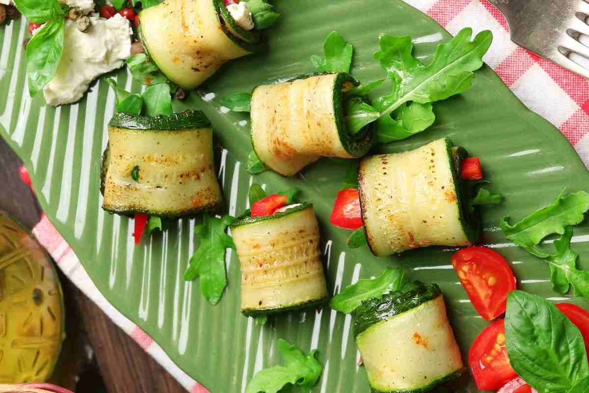 involtini di zucchine ripieni e serviti su una foglia grande e verde