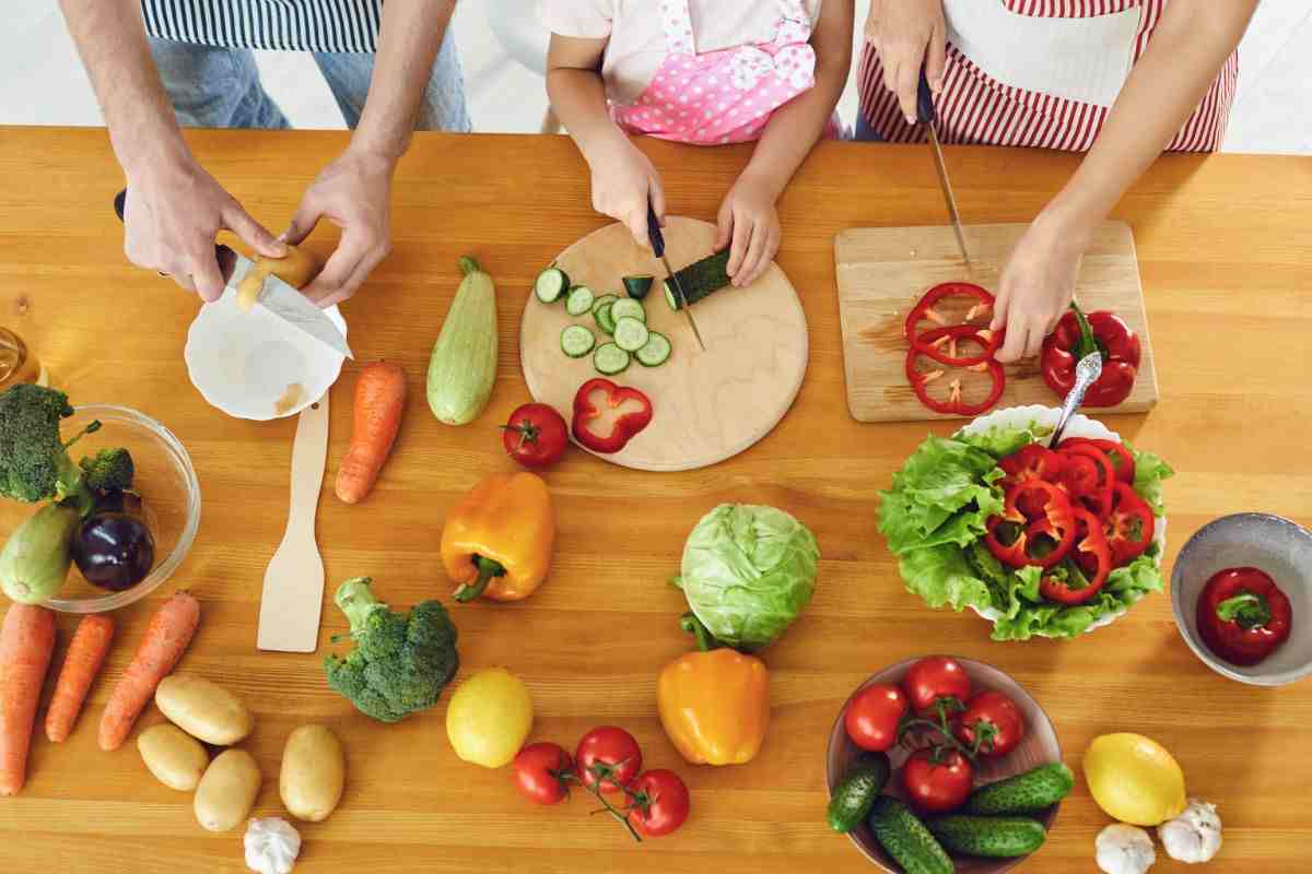persone tagliano verdure